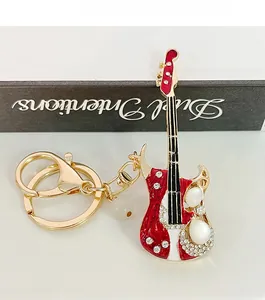Détail d'un porte-clés guitare rouge avec strass en cristal et finition alliage doré