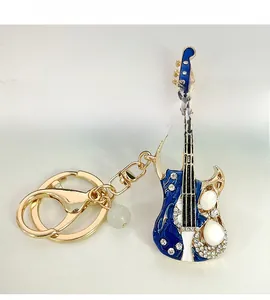 Détails d'un porte-clés guitare en émail bleu avec cristaux brillants et finition dorée