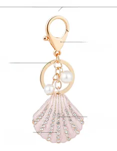 Detail view of pink enamel scallop keychain with crystal rhinestones and pearls