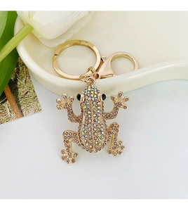 Detail view of crystal-encrusted frog keychain with golden lobster clasp and floral accents