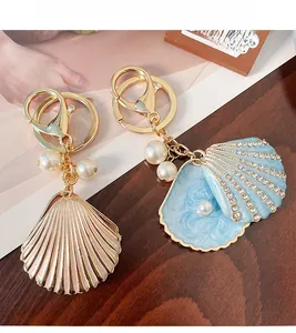 Detailed view of rhinestone shell keychains with blue enamel inlay and white pearls