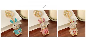 Detailed close-up showing blue, pink, and white crystal-studded rabbit keychains in a row