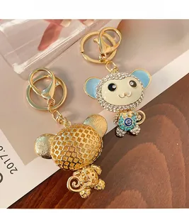 Dettaglio del portachiavi a forma di scimmia con motivo a trifoglio dorato e strass in smalto blu