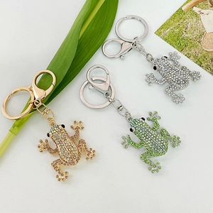 Three crystal frog keychains with rhinestones in gold, silver and green on a white background