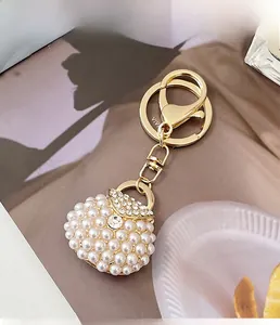 Close-up of pearl handbag keychain with rhinestones resting on a stylish magazine