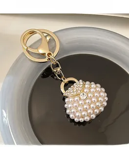 Detailed view of luxury handbag keychain with white pearls and sparkling rhinestones