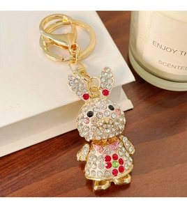 Close-up of a sparkling rabbit keychain with colorful rhinestones on a wooden desk