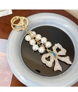 Close-up of a luxury bowknot keychain with pearls and crystals on a decorative tray