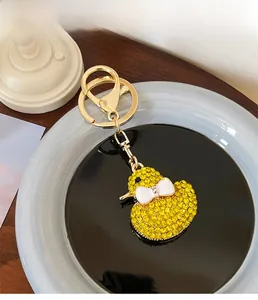 Detail of cute yellow crystal duck keychain with a sparkling bow on a golden clasp