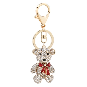 Exquisite teddy bear keychain with rhinestone finish and red bow on a golden metal clasp
