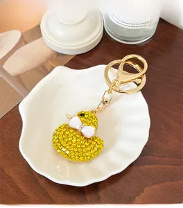 Detail of a sparkling yellow duck keychain with rhinestones and a gold lobster clasp