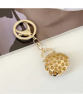 Detailed view of a golden pearl handbag keychain with intricate hollow metal mesh design