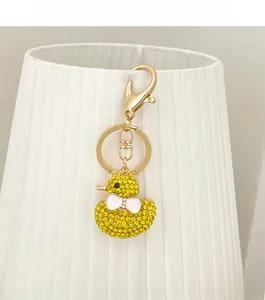 Detail of cute yellow duck keychain with sparkling rhinestones and golden lobster clasp