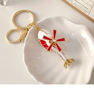 Close-up of helicopter keychain with red enamel wings and sparkling rhinestones