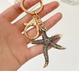 Detail of a sparkling starfish keychain with grey rhinestones and golden lobster clasp