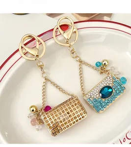 Gros plan de porte-clés sac à main en cristal de luxe avec strass bleus sur un plat en céramique