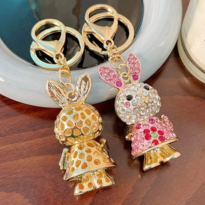 Sparkling rhinestone rabbit keychain set with gold hollow design on wooden background