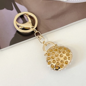 Golden handbag keychain with white pearls and luxury honeycomb metal cutout design
