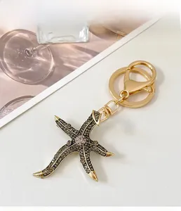 Detailed close-up of a starfish keychain with crystal rhinestones and golden alloy finish