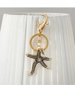 Detail of starfish keychain with dark grey rhinestones and large crystal on gold alloy