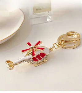 Detailed macro view of white helicopter keychain with red propellers and sparkling rhinestones