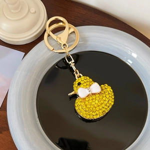 Sparkly yellow rhinestone duck keychain with a white bow and gold metal ring for bags