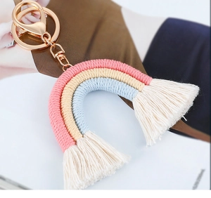 Close-up of handmade rainbow keychain with colorful cotton rope tassels and gold clasp