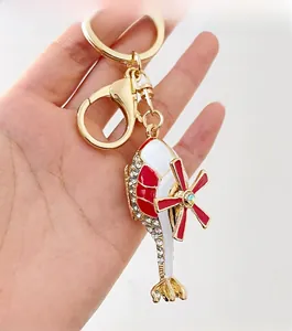 Detailed close-up of a crystal-studded helicopter keychain with red and white enamel finish