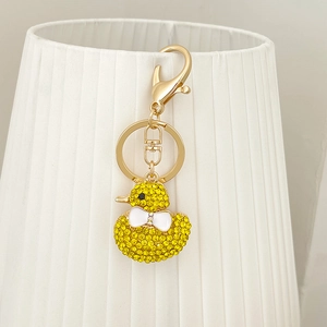 Sparkling yellow duck keychain with rhinestones and white bow on golden ring