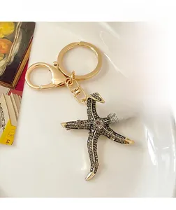 Macro shot of sparkling starfish bag charm with embedded crystals and gold keychain link