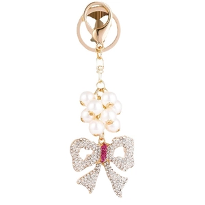 Elegant gold keychain with white pearls and a sparkling rhinestone-studded bow charm