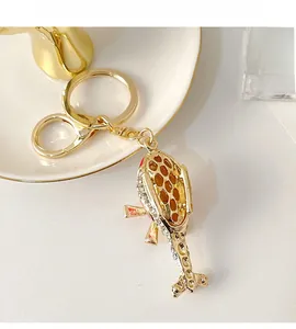 Macro shot of gold helicopter keychain with red enamel and sparkling rhinestones