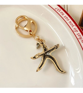 Macro shot of gold starfish pendant with dual-purpose keychain and brooch pin back