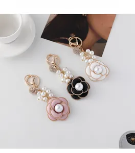 Detailed view of camellia flower keychains with pearls and sparkling crystals in 3 colors