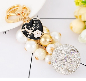 Macro shot of luxury heart keychain with number 5 charm and sparkling diamond ball
