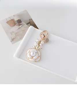 Close-up of camellia keychain with pearls, rhinestone ball and lobster clasp detail