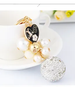 Detail of luxury keychain featuring pearl beads, diamond sphere, and flower charm