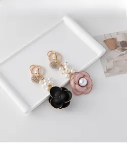 Detailed macro view of camellia fabric flower pendant with pearls and crystal bead