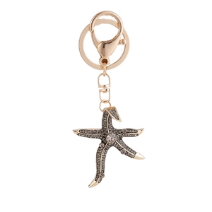 Golden starfish keychain with grey rhinestones and lobster clasp on white background