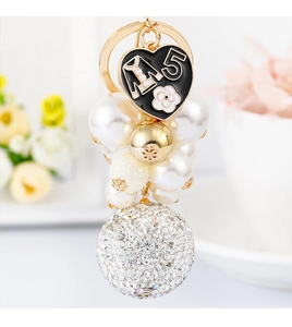 Detailed macro view of heart pendant with white pearls and sparkling rhinestone ball charm