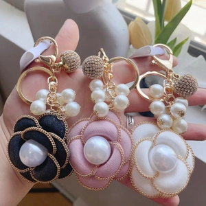 French camellia pearl keychain in black, pink, and white fabric with gold metal chain