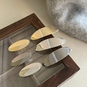 Set of minimalist gold and silver oval metal hair clips in various sizes for styling