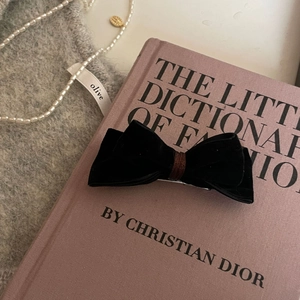 Detailed view of the black velvet bow hair clip with textured fabric and metal grip