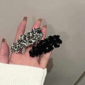 Elegant tweed hair clip set in black and white with subtle gold metallic threads
