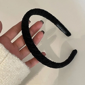 Close-up of black plaid headband texture with handmade label detail and fabric finish