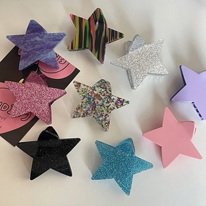 Vista piatta di nove pinze per capelli Y2K in acetato a stella con glitter e marmo