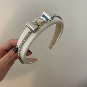 Eleganter weißer gepolsterter Haarreif mit silberner Metallschleife und Strasssteinen