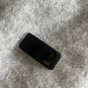 Detail of a black acetate rectangular hair clip with gold France Handmade lettering