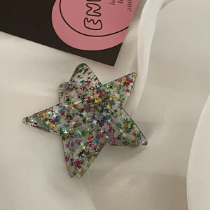 Macro della molletta per capelli y2k a stella con glitter colorati su seta bianca