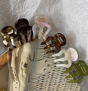Mini cellulose acetate hair claws showing diverse colors and French handmade logo details